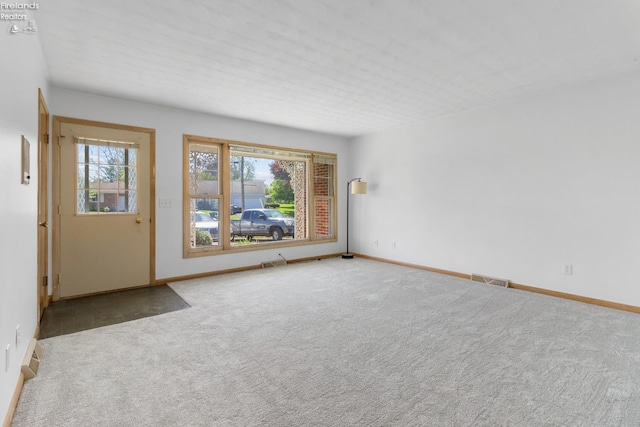 unfurnished room with carpet floors and baseboards