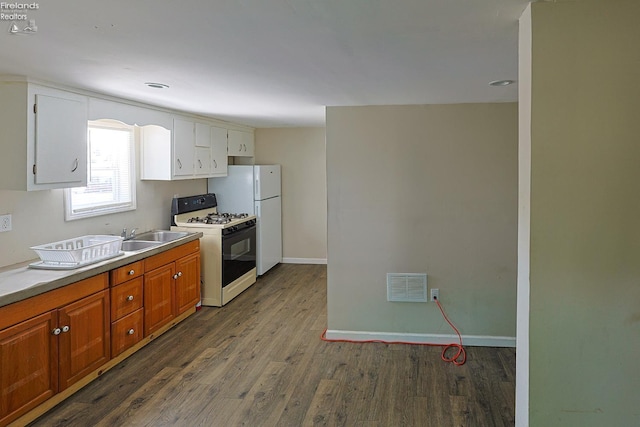 108 Spring St, Willard, OH 44890 - kitchen featuring white appliances, dark wood-type flooring, light countertops, brown cabinetry, and white cabinetry
