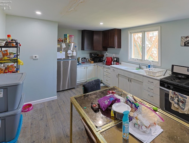 108 Spring St, Willard, OH 44890 - kitchen featuring stainless steel appliances, wood finished floors, light countertops, recessed lighting, and dark brown cabinetry