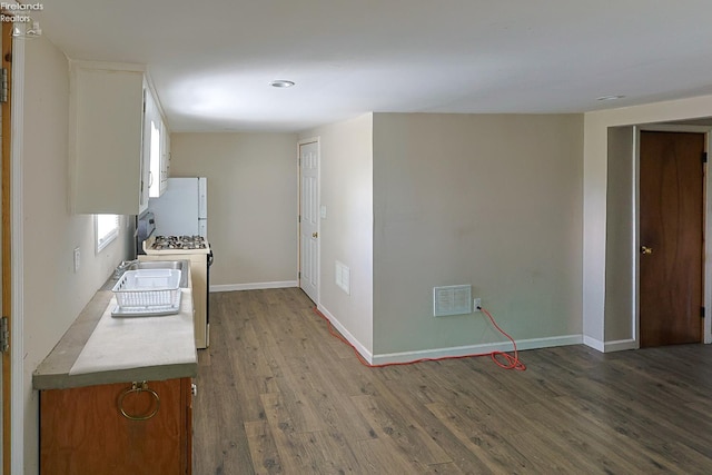 108 Spring St, Willard, OH 44890 - kitchen with white appliances, white cabinets, dark wood finished floors, and light countertops