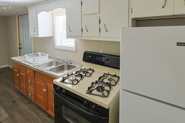 108 Spring St, Willard, OH 44890 - kitchen featuring freestanding refrigerator, range with gas stovetop, dark wood-style flooring, light countertops, and brown cabinetry