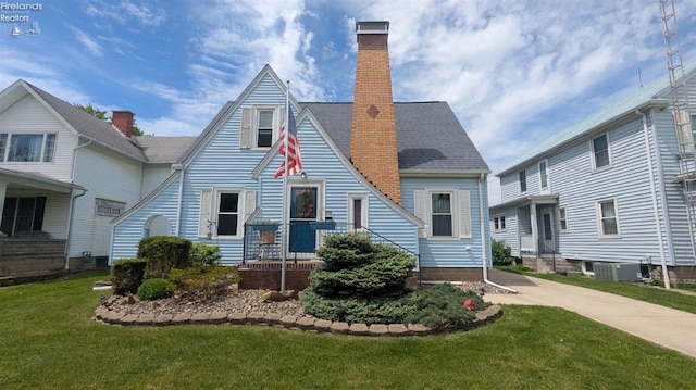206 Lincoln Dr, Port Clinton, OH 43452 - back of house featuring a chimney, cooling unit, and a lawn