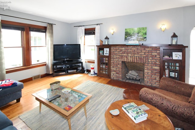 206 Lincoln Dr, Port Clinton, OH 43452 - living room featuring wood finished floors, a brick fireplace, and baseboards