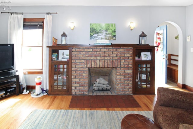 206 Lincoln Dr, Port Clinton, OH 43452 - living room featuring wood finished floors, a fireplace, and arched walkways