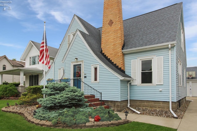 206 Lincoln Dr, Port Clinton, OH 43452 - view of front of property with a chimney, roof with shingles, and a garage