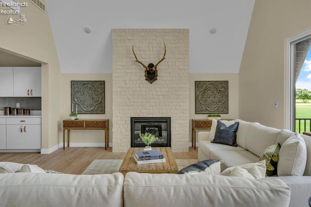 1861 N Opfer Lentz Rd, Martin, OH 43445 - living room featuring healthy amount of natural light, light wood-style flooring, vaulted ceiling, and a fireplace