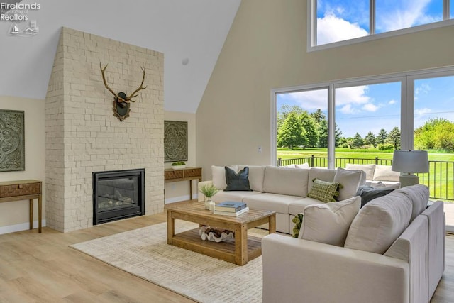 1861 N Opfer Lentz Rd, Martin, OH 43445 - living room featuring high vaulted ceiling, light wood finished floors, a fireplace, and baseboards