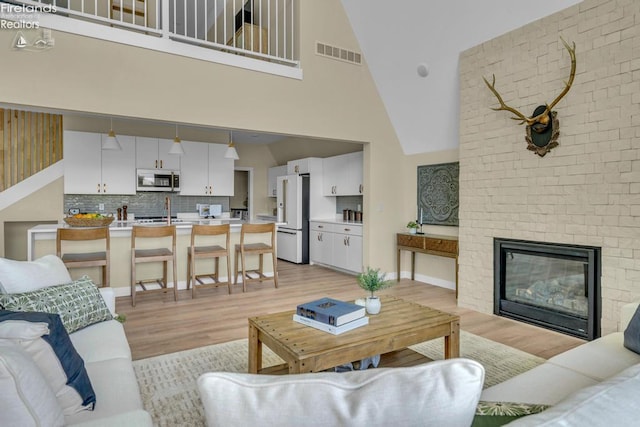 1861 N Opfer Lentz Rd, Martin, OH 43445 - living area featuring light wood-type flooring, high vaulted ceiling, and a brick fireplace