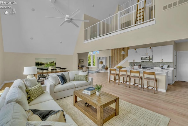 1861 N Opfer Lentz Rd, Martin, OH 43445 - living room featuring a high ceiling, ceiling fan, light wood-style flooring, and baseboards