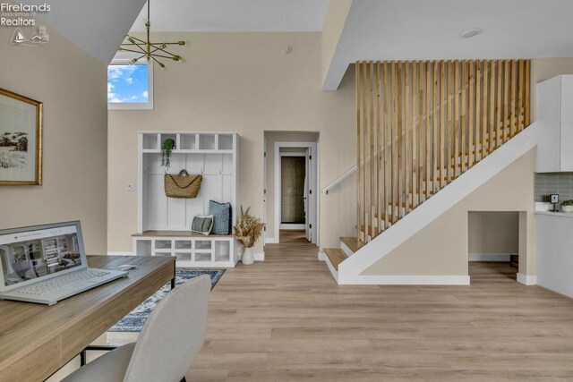 1861 N Opfer Lentz Rd, Martin, OH 43445 - foyer entrance featuring light wood-style flooring, stairs, baseboards, a high ceiling, and a chandelier