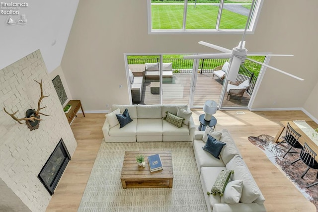 1861 N Opfer Lentz Rd, Martin, OH 43445 - living room featuring a glass covered fireplace, wood finished floors, baseboards, a high ceiling, and ceiling fan