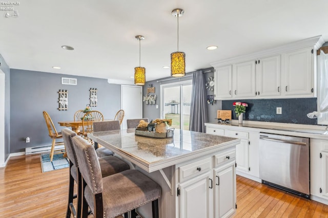 6518 W Township Road 112, Fostoria, OH 44830 - kitchen featuring dishwasher, a kitchen breakfast bar, a center island, light wood-style flooring, and a baseboard heating unit