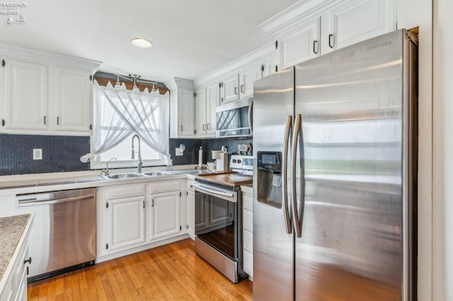 6518 W Township Road 112, Fostoria, OH 44830 - kitchen with appliances with stainless steel finishes, a sink, white cabinetry, and decorative backsplash