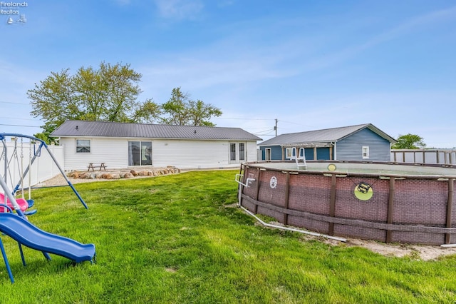 6518 W Township Road 112, Fostoria, OH 44830 - rear view of property featuring a playground, a yard, and metal roof