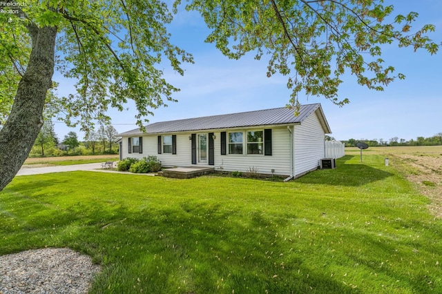 6518 W Township Road 112, Fostoria, OH 44830 - single story home with a front yard, metal roof, and central AC unit
