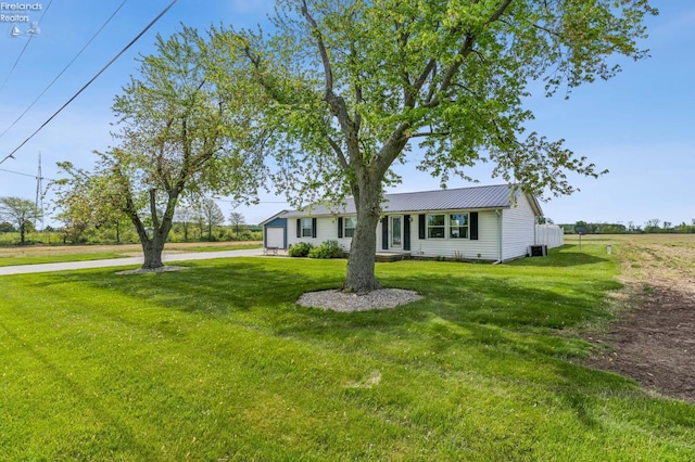6518 W Township Road 112, Fostoria, OH 44830 - view of front of home featuring concrete driveway, a front lawn, metal roof, and cooling unit