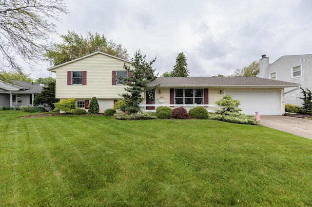 split level home with an attached garage, driveway, and a front yard
