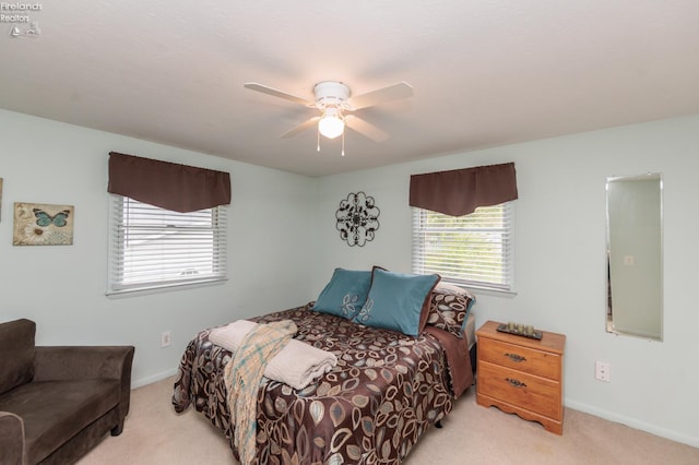 bedroom featuring light colored carpet, a ceiling fan, and baseboards