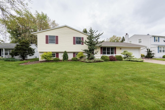 split level home with driveway, an attached garage, a chimney, and a front yard