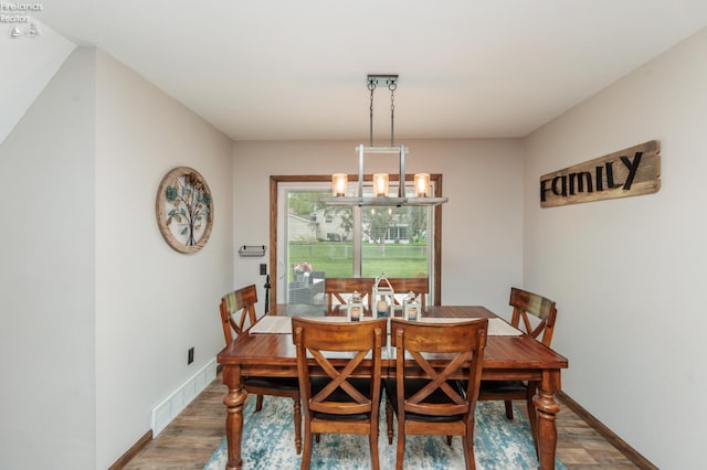 dining space with baseboards and a chandelier