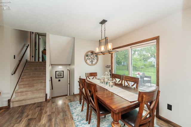 dining room with stairs, wood finished floors, a chandelier, and baseboards