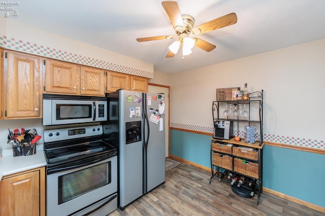 kitchen featuring appliances with stainless steel finishes, light wood-style floors, a ceiling fan, and light countertops