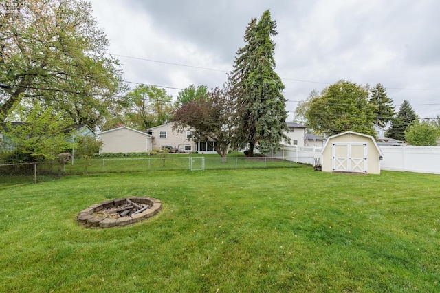 view of yard featuring a shed, an outdoor fire pit, and an outdoor structure