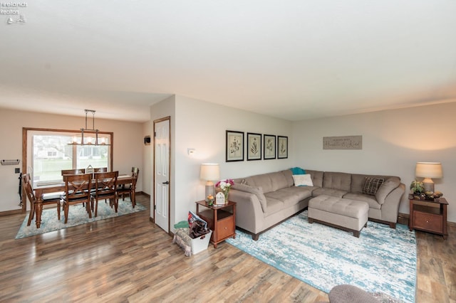 living area featuring wood finished floors, baseboards, and a chandelier