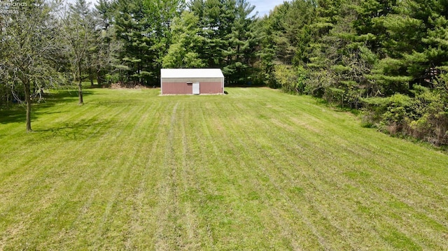 view of green lawn with an outdoor structure