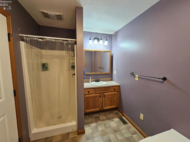 238 Nathan Dr, Clyde, OH 43410 - bathroom with baseboards, a stall shower, a textured ceiling, vanity, and tile patterned floors
