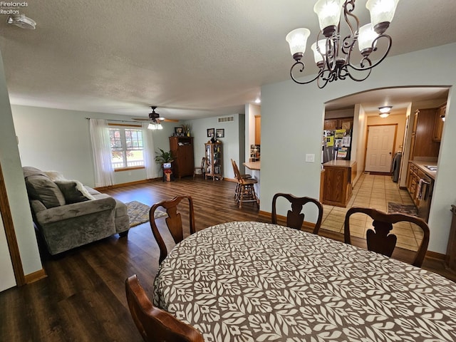238 Nathan Dr, Clyde, OH 43410 - dining room featuring light wood-style flooring, arched walkways, a textured ceiling, ceiling fan, and a chandelier