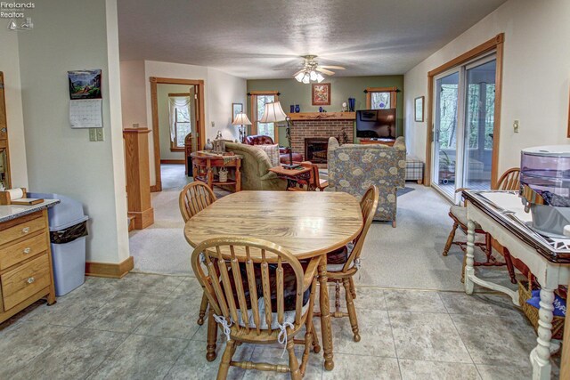 914 Wood Glen Ct, Norwalk, OH 44857 - dining space featuring a ceiling fan, plenty of natural light, a brick fireplace, and light carpet