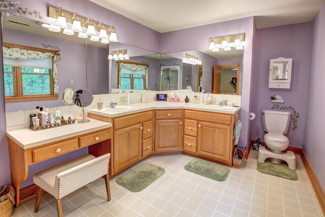914 Wood Glen Ct, Norwalk, OH 44857 - full bathroom with double vanity, toilet, a shower with shower door, and tile patterned floors