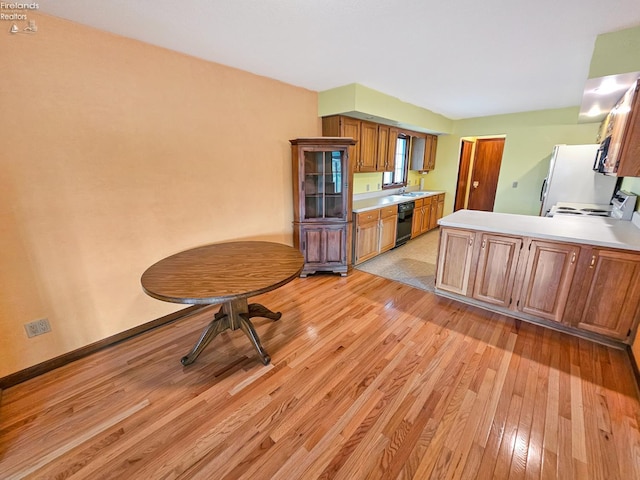 110 Orchard Grove Dr, Clyde, OH 43410 - kitchen with dishwasher, light wood-style flooring, light countertops, and brown cabinets
