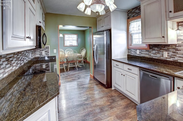 5475 E Mabel Dr, Port Clinton, OH 43452 - kitchen with stainless steel appliances, dark wood finished floors, dark stone counters, and backsplash