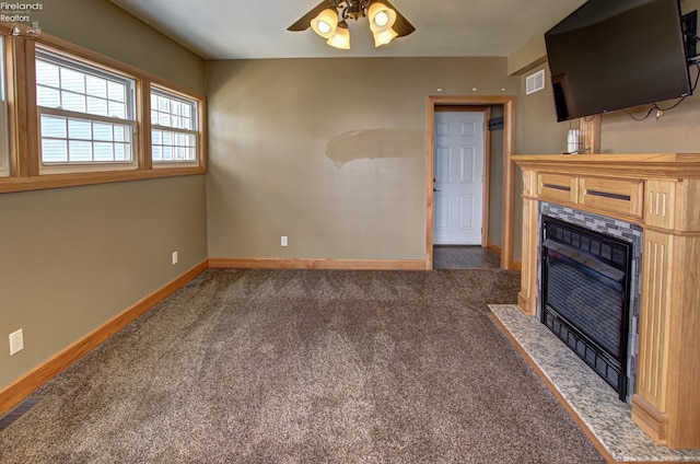 5475 E Mabel Dr, Port Clinton, OH 43452 - unfurnished living room featuring a tiled fireplace, baseboards, carpet floors, and a ceiling fan