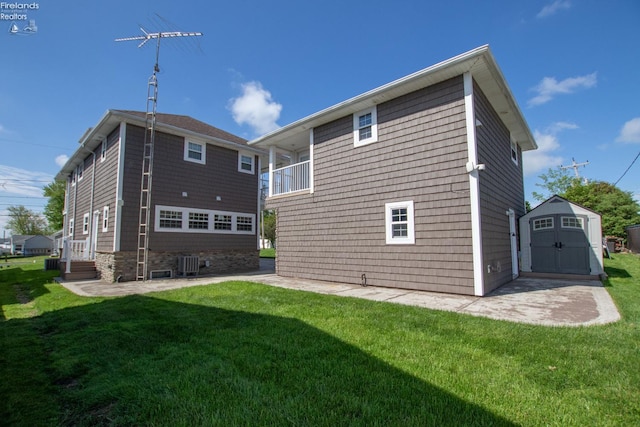 5475 E Mabel Dr, Port Clinton, OH 43452 - rear view of house with a storage shed, a lawn, and a patio