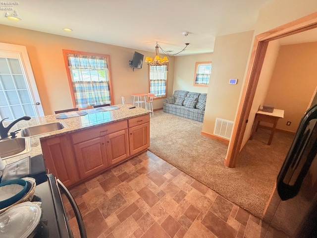 5475 E Mabel Dr, Port Clinton, OH 43452 - kitchen with light colored carpet, a chandelier, a sink, recessed lighting, and light stone finish floors