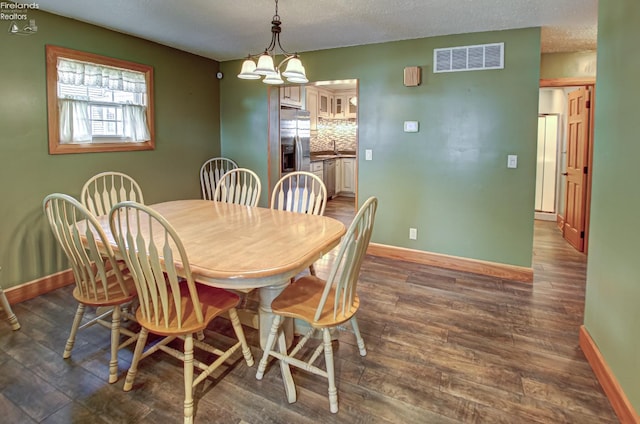 5475 E Mabel Dr, Port Clinton, OH 43452 - dining space with baseboards, dark wood-type flooring, a chandelier, and a textured ceiling
