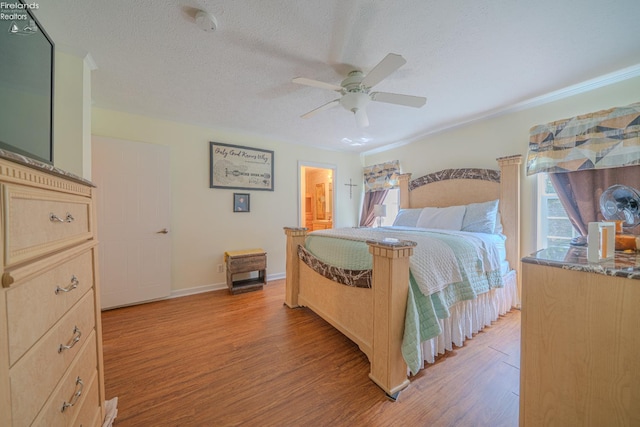 8896 White Crane Way, Oak Harbor, OH 43449 - bedroom featuring light wood-type flooring, baseboards, ceiling fan, ensuite bath, and a textured ceiling