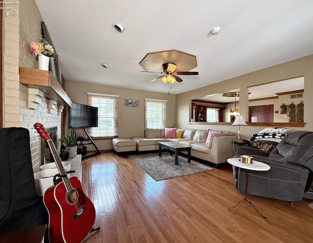 38 N Tecumseh Trl, Tiffin, OH 44883 - living area with ceiling fan, wood finished floors, a brick fireplace, and baseboards