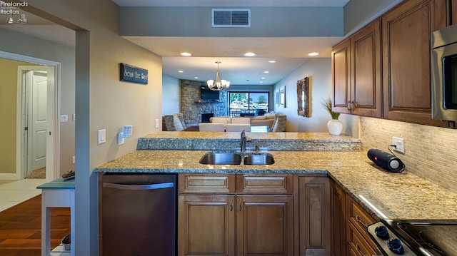 3088 N Marina View Dr Unit 12, Port Clinton, OH 43452 - kitchen with appliances with stainless steel finishes, a sink, decorative backsplash, a chandelier, and light stone counters