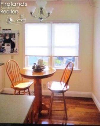 720 S Myrtle Ave, Willard, OH 44890 - dining space with a chandelier, baseboards, and wood finished floors