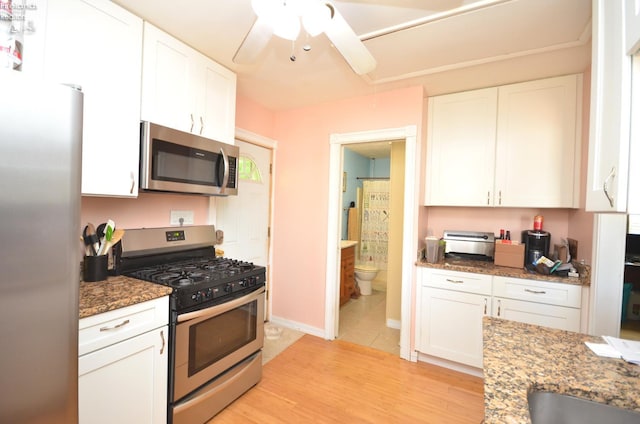 765 Riverside, Vermilion, OH 44089 - kitchen with appliances with stainless steel finishes, white cabinets, stone counters, ceiling fan, and light wood-style floors