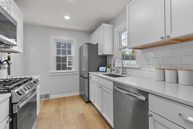 625 Laurel Ave, Port Clinton, OH 43452 - kitchen with appliances with stainless steel finishes, a sink, decorative backsplash, white cabinets, and recessed lighting