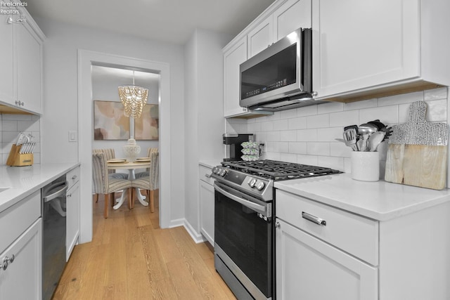 625 Laurel Ave, Port Clinton, OH 43452 - kitchen featuring appliances with stainless steel finishes, a chandelier, light wood-style flooring, and white cabinetry