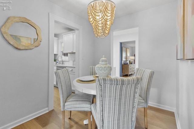 625 Laurel Ave, Port Clinton, OH 43452 - dining area featuring a chandelier, light wood finished floors, and baseboards