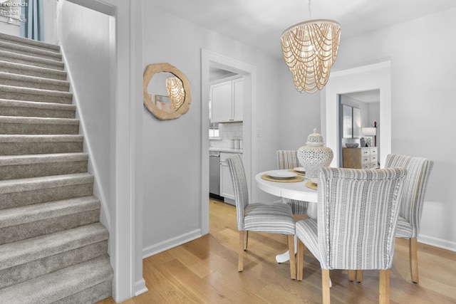 625 Laurel Ave, Port Clinton, OH 43452 - dining space with a chandelier, stairway, light wood-style flooring, and baseboards