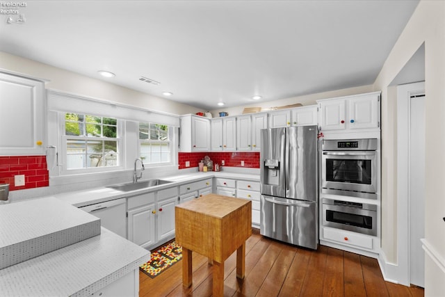 236 Elm Ave, Lakeside, OH 43440 - kitchen with stainless steel appliances, a sink, light countertops, dark wood finished floors, and white cabinets