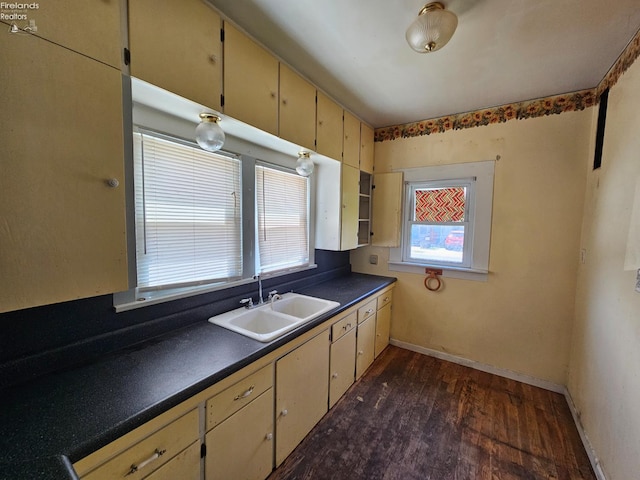 202 Duane St, Clyde, OH 43410 - kitchen featuring a sink, dark countertops, dark wood finished floors, baseboards, and cream cabinets